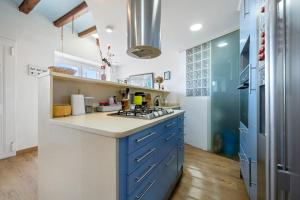 a kitchen with blue and white counters and a refrigerator at Voramar in Torredembarra +15 photos