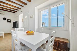 a white dining room with a white table and chairs at Voramar in Torredembarra