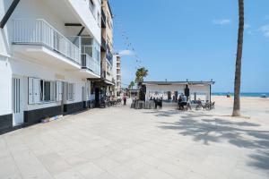 a building on the beach next to the ocean at Voramar in Torredembarra