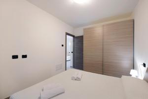 a white bedroom with a bed and a sliding glass door at Appartamento 2 in Nesso +19 photos