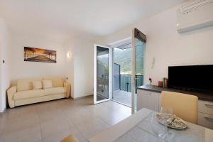 a living room with a couch and a television at Appartamento 2 in Nesso