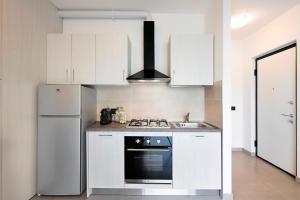 a white kitchen with a stove and a refrigerator at Appartamento 2 in Nesso