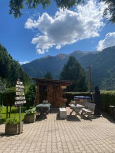 a patio with a table and a sign and mountains at Studio Pepper in Stall