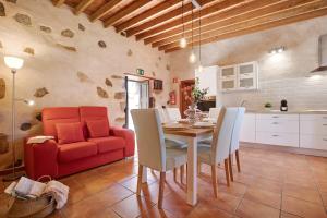 a kitchen and dining room with a table and a red couch at Casa Rural Andresito in Pájara