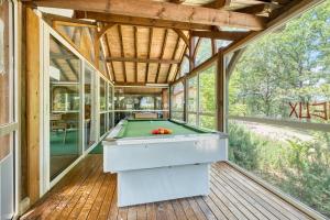 a pool table in a room with windows at Gite Gariotte in Salignac Eyvigues