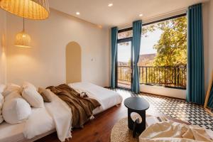 a bedroom with a bed and a large window at BeYouth Hotel Dalat Valley View in Da Lat