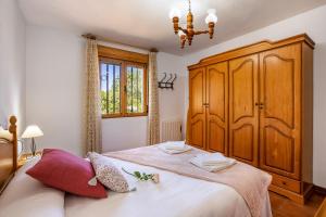 a bedroom with a large bed and a wooden cabinet at Ladera de los molinos in Padul +27 photos