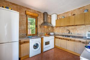 a kitchen with a washing machine and a washer at Ladera de los molinos in Padul
