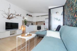a living room with a blue couch and a tv at Sa Perdiu 14 Menorca in Cala Santandria