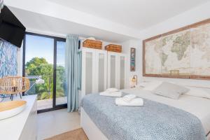 a bedroom with a bed and a large window at Sa Perdiu 14 Menorca in Cala Santandria +16 photos