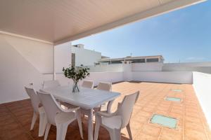 a white dining table and chairs on a balcony at Ganivet Home in Arrecife