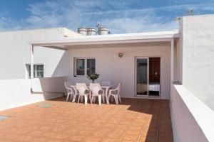 a patio with a table and chairs on a house at Ganivet Home in Arrecife