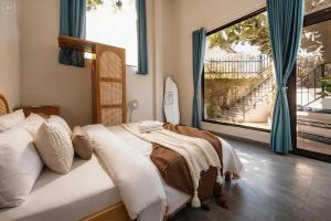 a bedroom with a bed and a large window at BeYouth Hotel Dalat Valley View in Da Lat +36 photos