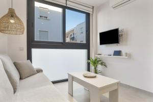 a living room with a couch and a table at Apartamento Black Palm 1 9 in Tarifa