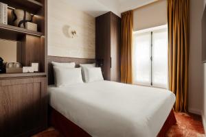 a bedroom with a large bed and a window at Jills Hôtel in Paris +25 photos