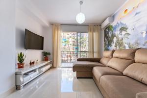 a living room with a couch and a flat screen tv at Casa de Bella Fuengirola in Fuengirola