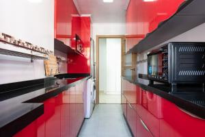 a red kitchen with a microwave and red walls at Casa de Bella Fuengirola in Fuengirola