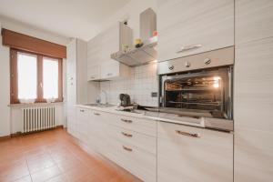 a kitchen with white cabinets and an oven at La Fenice Private Gardent Free in Rivoli Veronese +24 photos