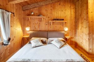 a bedroom with a bed in a wooden wall at Chalet Del Cuore in Valdisotto