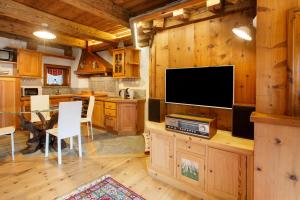 a kitchen and dining room with a large flat screen tv at Chalet Del Cuore in Valdisotto