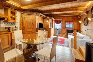 a kitchen and living room with a glass table at Chalet Del Cuore in Valdisotto