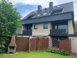 a house with a wooden fence in front of it at Ferienwohnung Halvar in Maasholm