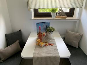 a white table with a bottle of wine and drinks on it at Ferienwohnung Halvar in Maasholm