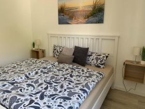 a bedroom with a bed with a black and white comforter at Ferienwohnung Halvar in Maasholm