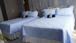 two beds with blue and white sheets and pillows at Precious Guest House in Manamakgoteng +42 photos