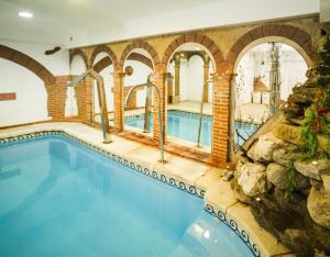 a swimming pool in a house with a rock wall at La Chirumba in Aldeatejada