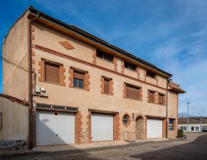 an old brick building with three garage doors at La Chirumba in Aldeatejada