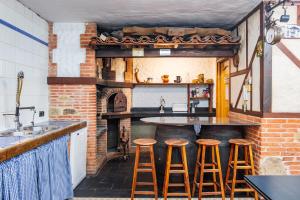 a kitchen with a counter with stools at a bar at La Chirumba in Aldeatejada