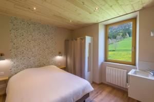 a bedroom with a bed and a sink and a window at Gîte Le Chalimont in Saint-Julien-en-Vercors