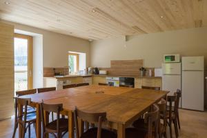 a kitchen with a large wooden table and chairs at Gîte Le Chalimont in Saint-Julien-en-Vercors