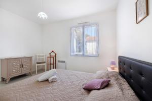 a bedroom with a large bed with purple pillows at Le Cœur de Tranche - proche mer in La Tranche-sur-Mer