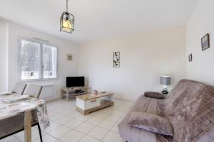 a living room with a couch and a table at Le Cœur de Tranche - proche mer in La Tranche-sur-Mer