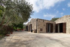 an old stone building with a tree next to it at Casa Il Carrubbo in Modica