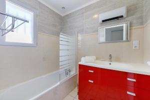 a bathroom with a red cabinet and a red sink at Le Cœur de Tranche - proche mer in La Tranche-sur-Mer +18 photos