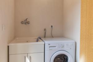 a laundry room with a washing machine and a sink at Casa Il Carrubbo in Modica