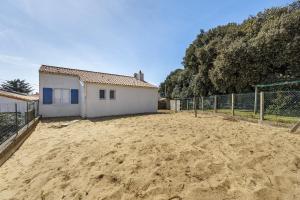 a dirt yard with a building and a fence at Le Cœur de Tranche - proche mer in La Tranche-sur-Mer