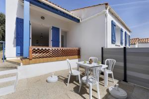a patio with a table and chairs on a house at Le Cœur de Tranche - proche mer in La Tranche-sur-Mer