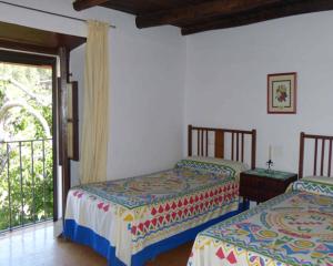 two beds in a room with a balcony at Los Cascos in Fuenteheridos
