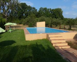 a swimming pool in a yard with a grass field at Los Cascos in Fuenteheridos