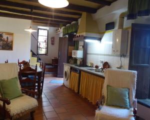 a kitchen with a sink and a counter with chairs at Los Cascos in Fuenteheridos