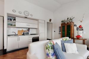ein Wohnzimmer mit weißem Sofa und eine Küche in der Unterkunft Chiavari Elegante in Chiavari