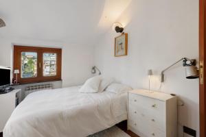 ein weißes Schlafzimmer mit einem Bett und einem Fenster in der Unterkunft Chiavari Elegante in Chiavari