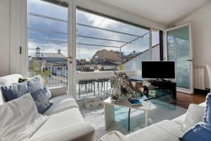 ein Wohnzimmer mit weißem Sofa und großem Fenster in der Unterkunft Chiavari Elegante in Chiavari