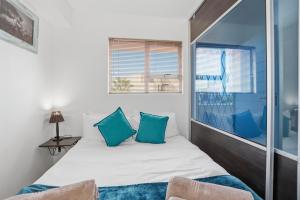 a small bedroom with a bed and a window at Nautica by the Sea in Cape Town +18 photos