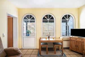 a living room with a table and three windows at Ferienwohnung 2 in Bernkastel-Kues
