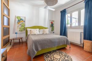 a bedroom with a green bed and blue curtains at House in Villa Torto in Monopoli +32 photos